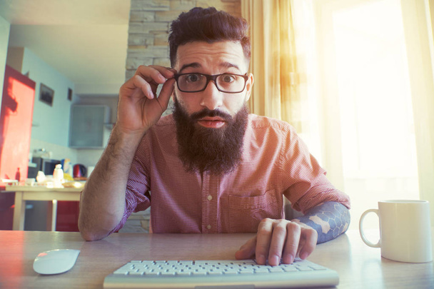 Funny bearded man looking at computer - Foto, afbeelding