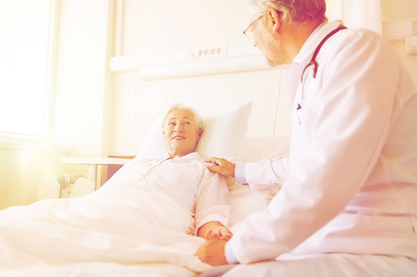 лікар, який відвідує старшу жінку в лікарняному палаті
 - Фото, зображення