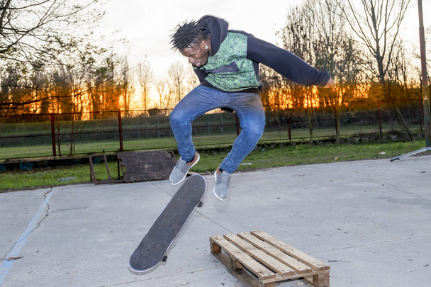 Junger Skateboarder springt im Freien auf eine Rampe - Foto, Bild