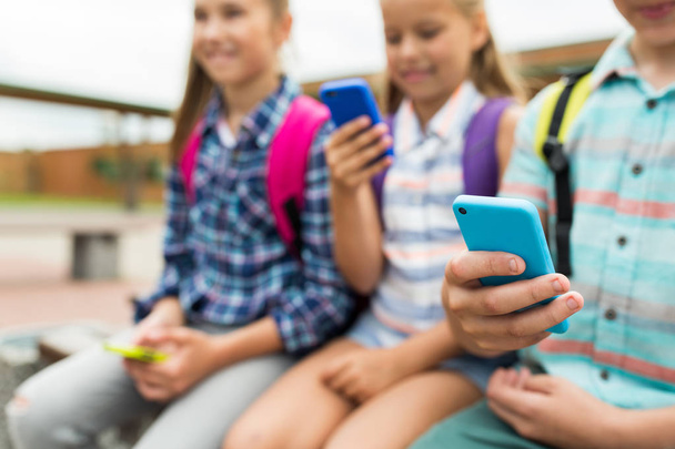 elementary school students with smartphones - Foto, Imagen