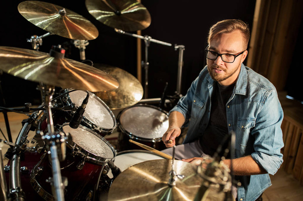 male musician playing drums and cymbals at concert - Foto, Bild