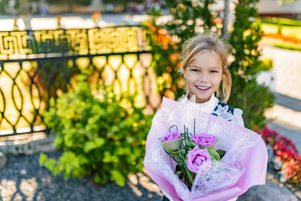 Красива маленька дівчинка з великим букетом квітів
 - Фото, зображення