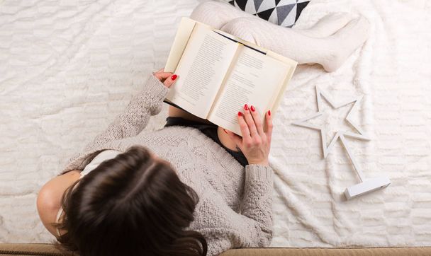 Жінка відпочиває з книгою вдома
 - Фото, зображення