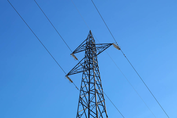 Słupy elektryczne wysokiego napięcia w białe chmury i błękitne niebo - Zdjęcie, obraz