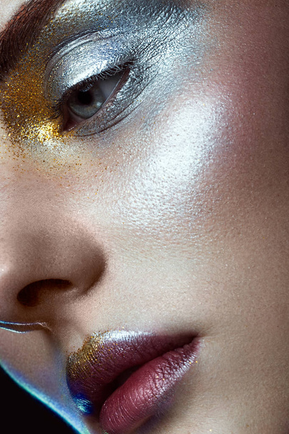 Beautiful girl with creative golden and silver glitter make-up. beauty face. - Fotó, kép