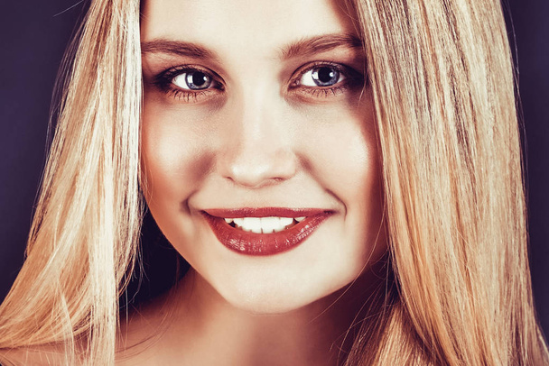 schöne junge blonde Frau mit langen glatten Haaren auf dunklem Hintergrund - Foto, Bild