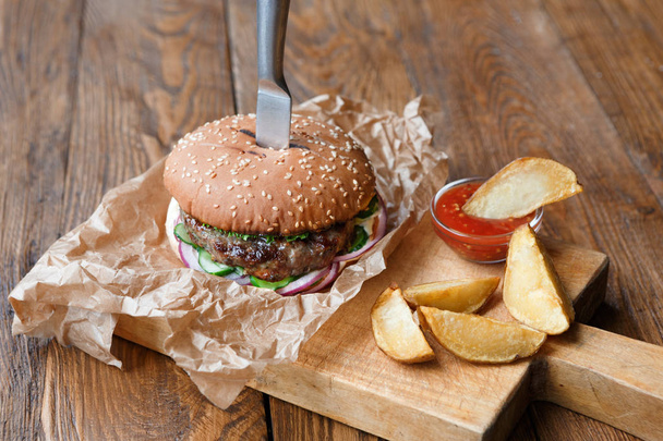 Fast Food auf einem Holztisch im Restaurant. Burger und Kartoffelkeile - Foto, Bild
