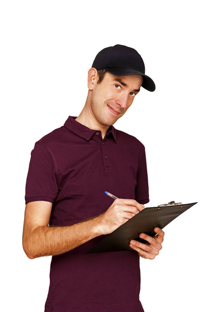 Smiling delivery man holding clipboard on white background - Photo, Image