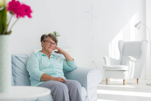 Senior woman sitting on sofa - Fotó, kép