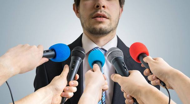 Politiker redet und gibt Reportern Interviews. viele Mikrofone, die ihn vor. - Foto, Bild