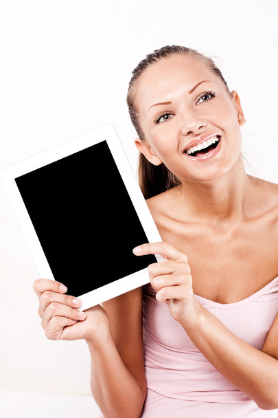 Улыбающаяся молодая красивая женщина с планшетным компьютером дома
 - Фото, изображение