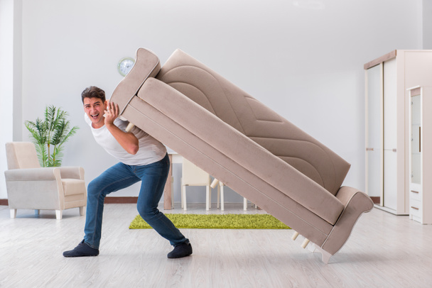 Man moving furniture at home - 写真・画像