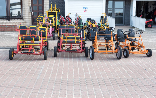 Bicicletas y coches de guerra para pedir prestado en el paseo marítimo de Koksijde, Bélgica
 - Foto, Imagen