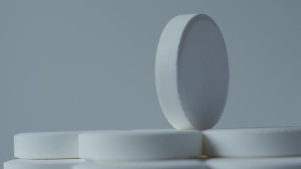 białe tabletki toczenia na białym tle - Materiał filmowy, wideo