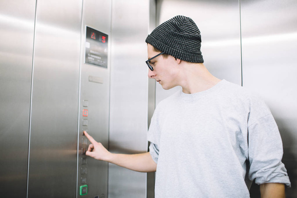 Young stylish guy standing in elevator - Foto, Imagen