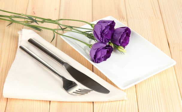Tableware with flower on bright napkin close-up - Foto, afbeelding