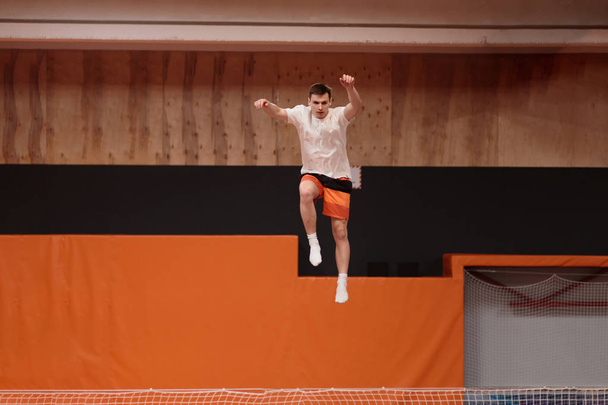 Young athlete on the trampoline in graceful flight. - Foto, Imagen