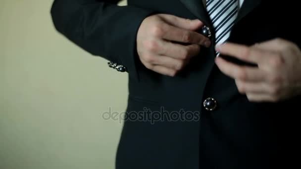 Man in stripped suit buttons up his black jacket - Filmmaterial, Video
