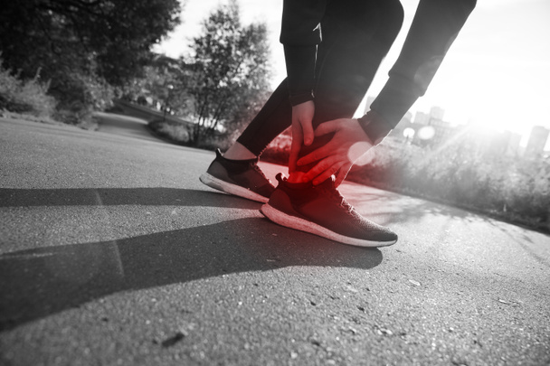 Atlético homem corredor tocando pé na dor devido a torção no tornozelo
 - Foto, Imagem