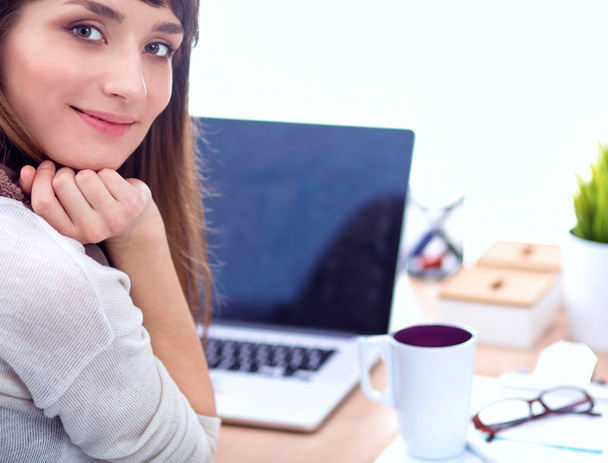 Portrait of  woman sitting at  desk with a laptop - Foto, imagen