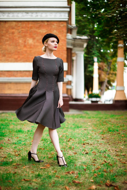 Beautiful attractive blonde girl in a dress and beret outdoors - Photo, Image