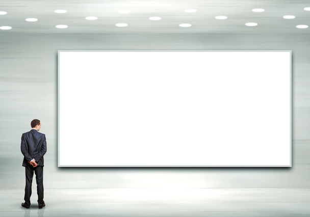 Business person standing near a blank billboard - Foto, Imagen
