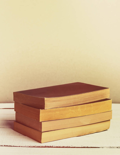Винтажные книги в мягкой обложке на деревянном столе. Принято. Вертикальное изображение. Ретро
 - Фото, изображение