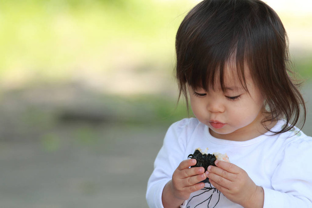 Japanese girl eating rice ball (1 year old) - Fotografie, Obrázek
