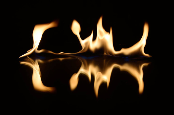   flames on a black background with mirror reflection - Fotó, kép