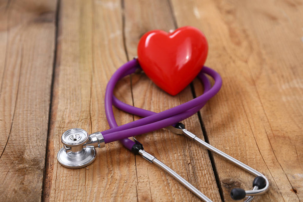 Heart with a stethoscope, isolated on wooden background - Valokuva, kuva