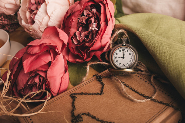 Note en papier artisanal avec tasse de thé, fleurs, pivoines, vieille horloge vintage. Fond rétro
. - Photo, image