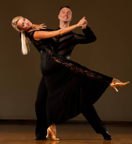 Beautiful ballroom  couple preforms their exhibition dance - Фото, изображение