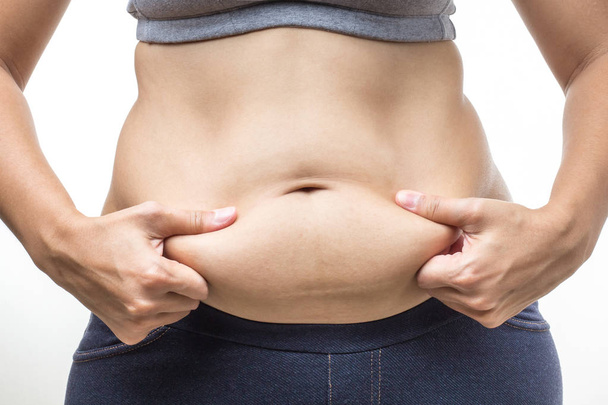 mujer con sobrepeso con la mano sosteniendo la grasa del vientre
 - Foto, imagen