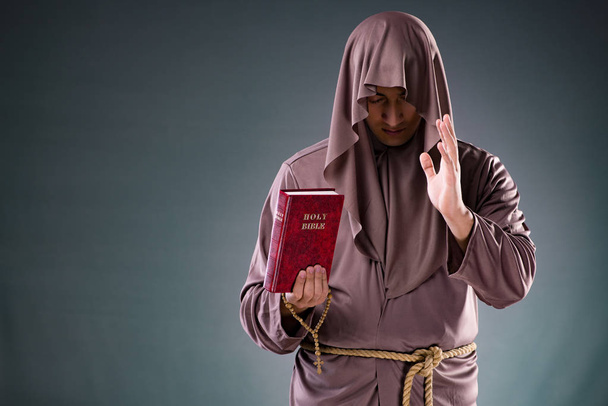 Monk in religieuze concept op grijze achtergrond - Foto, afbeelding