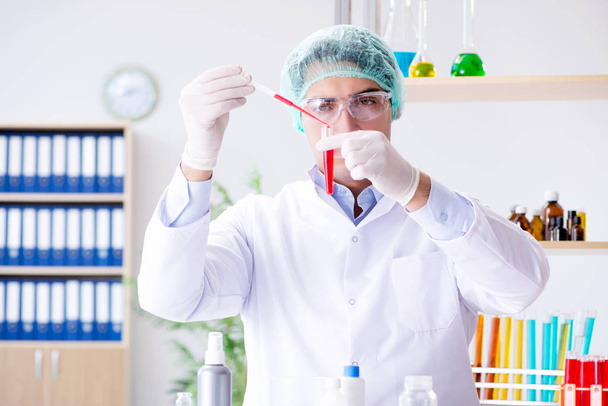 Tests sanguins en laboratoire avec un jeune scientifique - Photo, image