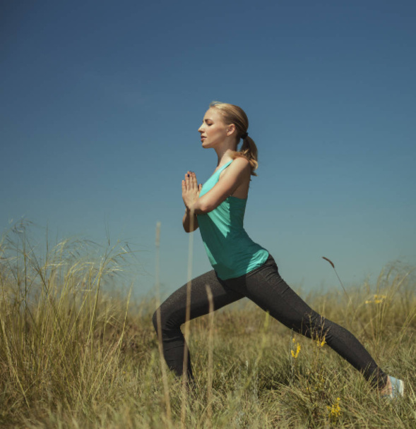 Beautiful young blond woman exercising in the outdoors yoga phot - 写真・画像