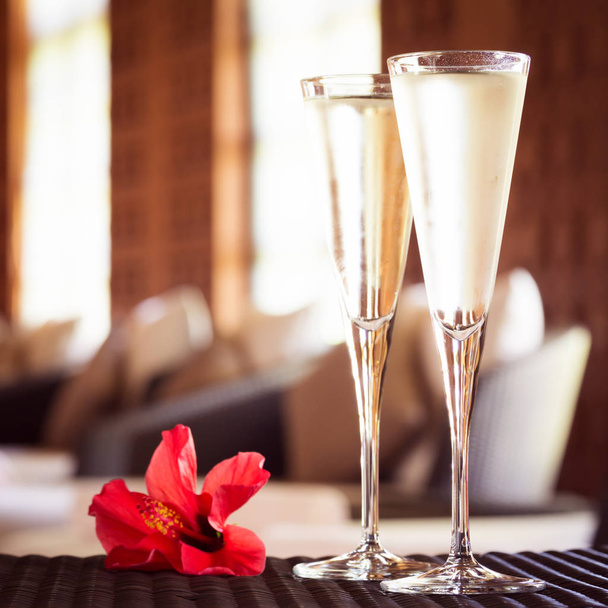 İki bardak şampanya bir spa salonda kırmızı çiçekli. Spa ti - Fotoğraf, Görsel