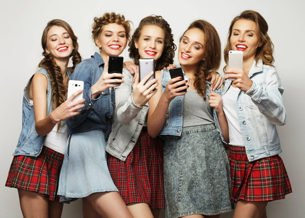 group of young women looking at their smartphones - Фото, зображення