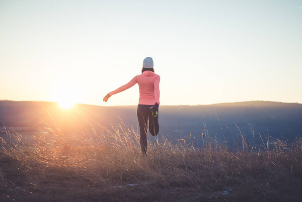 Běžec dívka táhnoucí se na vrcholu kopce - Fotografie, Obrázek