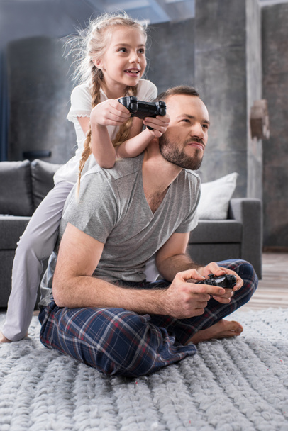 Father and daughter playing with joysticks - 写真・画像