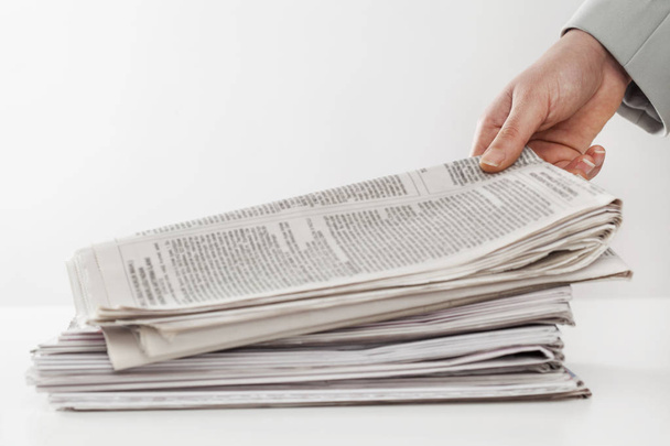 Mulher mão segurando jornais na mesa
 - Foto, Imagem