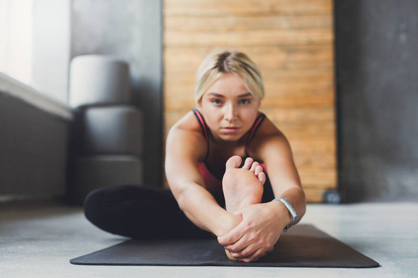Woman makes yoga pose in class, sit forward bend asana - Foto, immagini