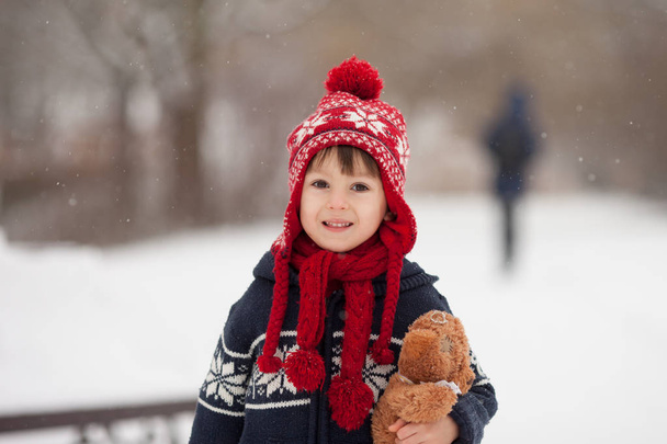 Cute little caucasian boy with teddy bear and red lantern, playi - Фото, изображение