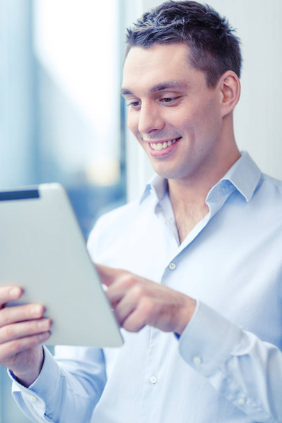 smiling businessman with tablet pc in office - Zdjęcie, obraz
