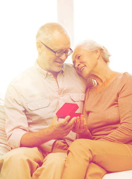 happy senior couple with red gift box at home - Photo, image