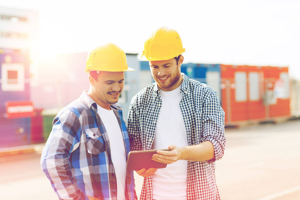 two smiling builders in hardhats with tablet pc - Fotoğraf, Görsel
