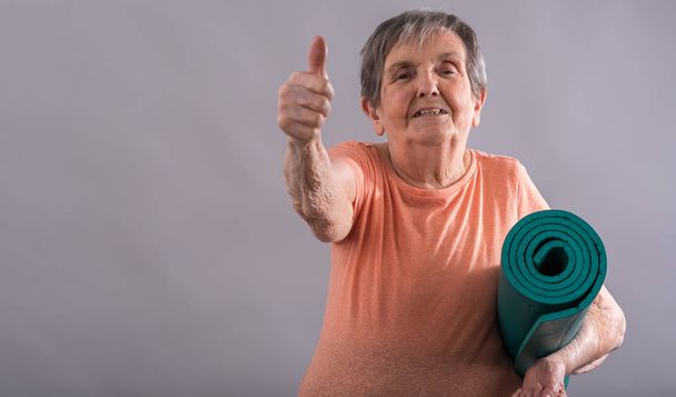 ältere Frau mit Yogamatte - Foto, Bild