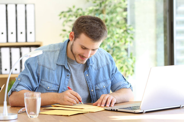 Entrepreneur writing adress in a padded envelope - Foto, Imagem