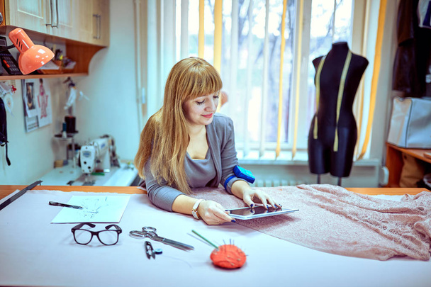 Fashion designer looking at sketches in studio - Foto, Bild