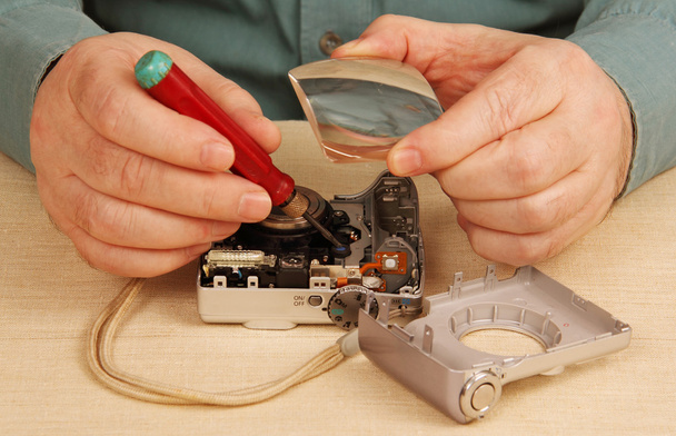 Digital camera repair. Handyman, tools, magnifier. - Photo, Image